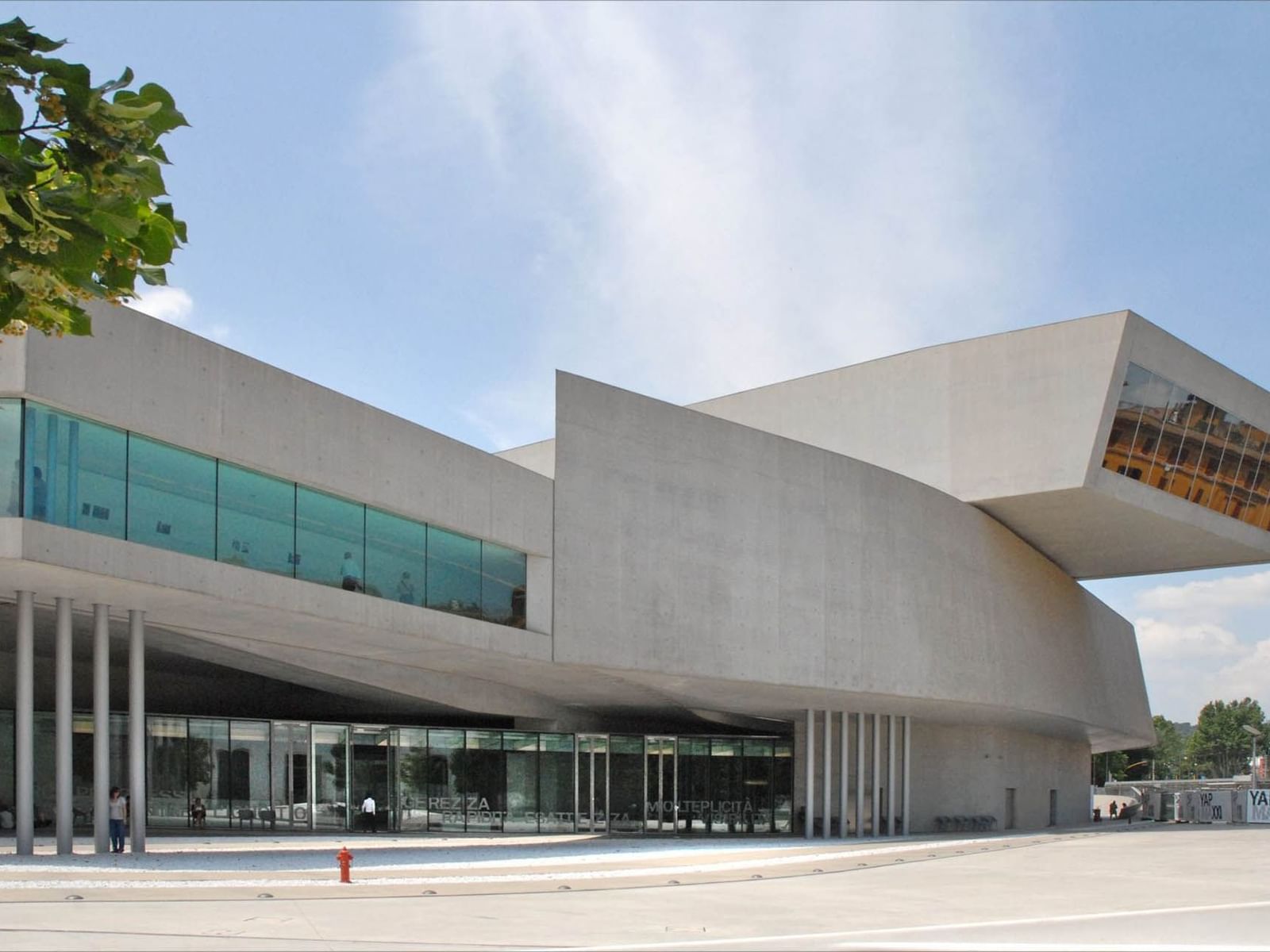 Modern MAXXI Museum with sleek design and large glass windows under a clear blue sky near The Guardian Hotel