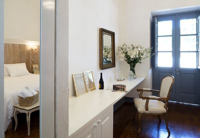 White desk by a classic armchair under a gold mirror by a door in a room at NOI Blend Colchagua, Chile
