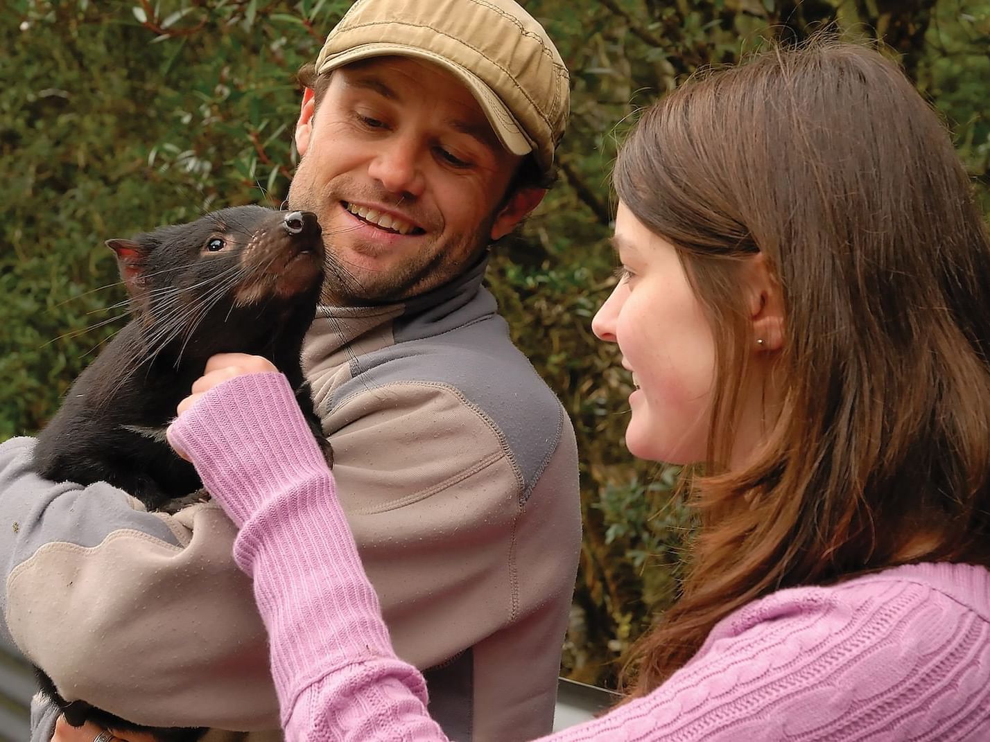 Couple petting a Tasmanian Devil near Cradle Mountain Hotel