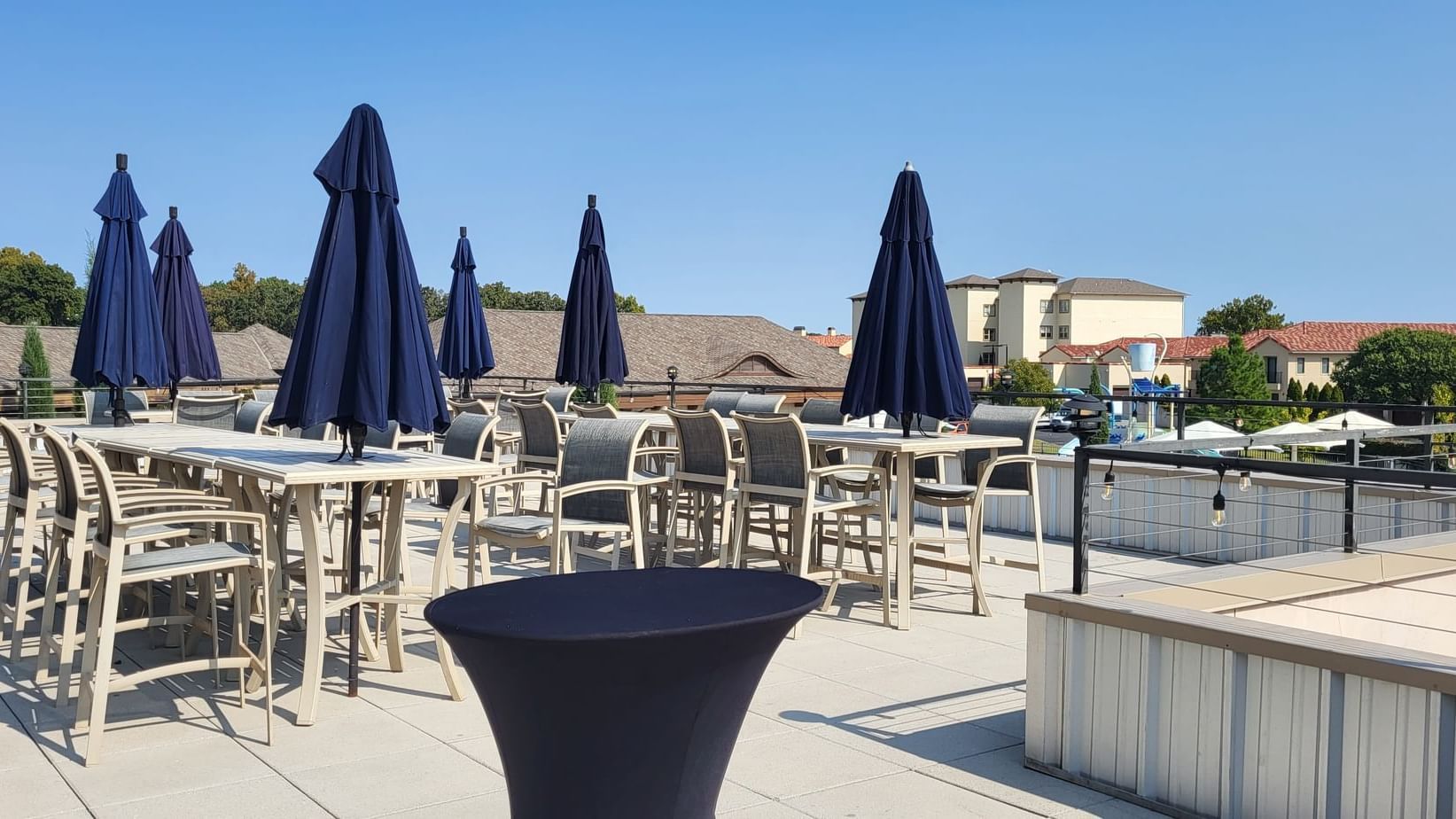 Rooftop Patio with tables, chairs, and dark umbrellas at Shangri-La Monkey Island