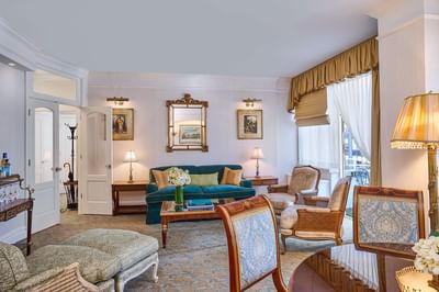Green sofa between lamps and beside armchairs facing coffee table in luxury suite at The Kimberly Hotel