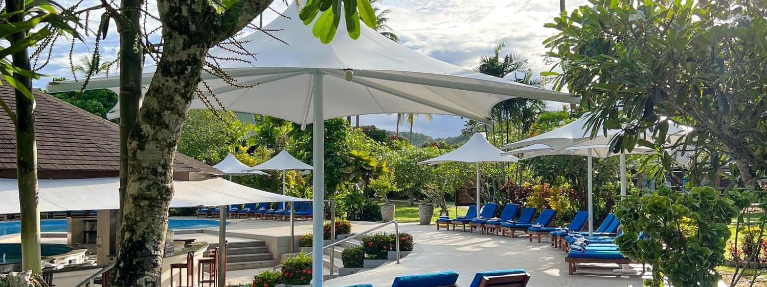 Sun loungers and umbrellas at the swimming pool area at The Naviti Resort in Korolevu.