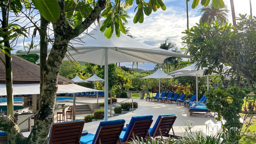 Sun loungers and umbrellas at the swimming pool area at The Naviti Resort in Korolevu.