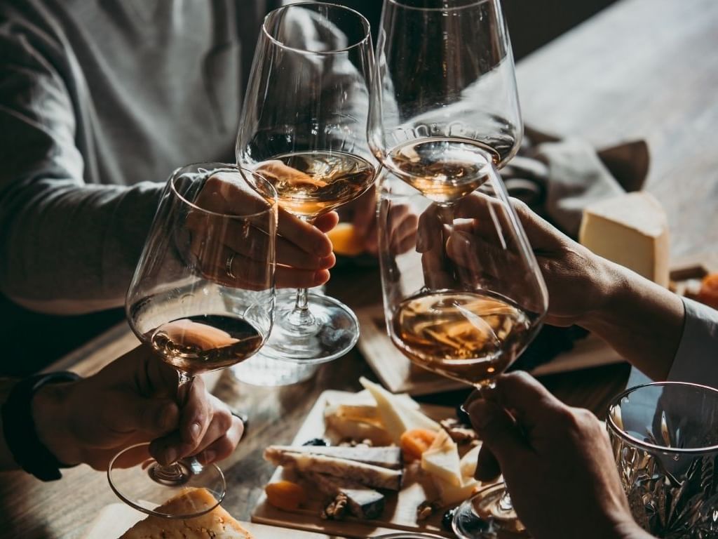 Friends toasting with wine glasses over a table with antipasto for a Gourmet Traveller Deluxe Brisbane Stay experience.