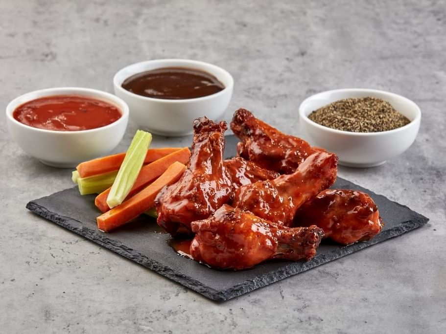 Buffalo wing dish served with sauce & pepper at One Hotels