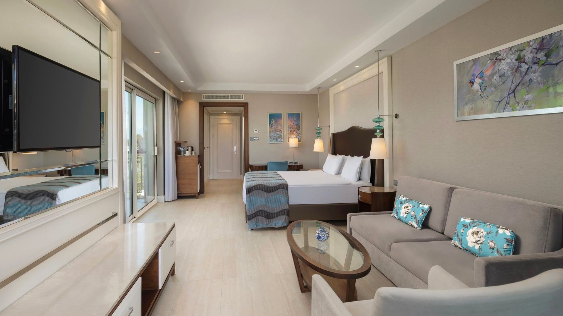 Spacious Riverside Room with modern furnishings, balcony access, and elegant decor at Titanic Deluxe Golf Belek, Antalya.