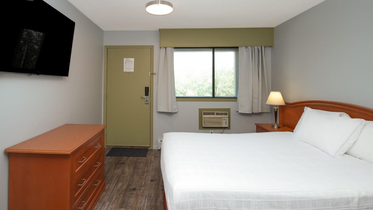 Guest room at Coast Red Deer Hotel with queen bed, dresser and TV