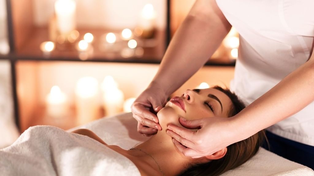 Woman receiving a relaxing facial massage by a professional in a spa setting.