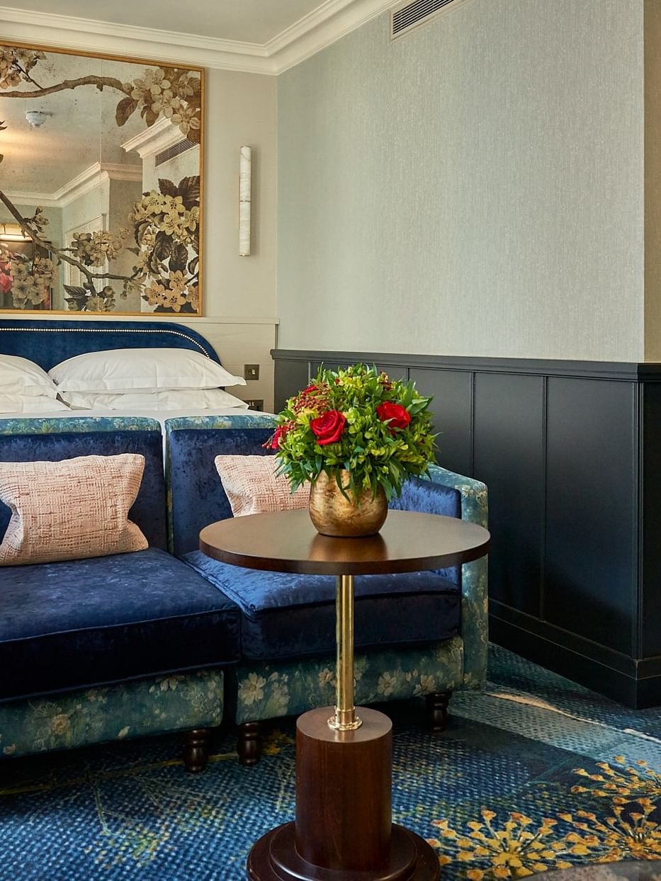 Deluxe King room with blue velvet seating, king bed, and decorative mirror at The Capital Hotel, Apartments & Townhouse.
