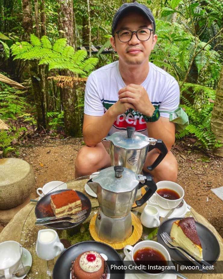 A man was taking pictures with the dishes at Kopi Hutan - Lexis Suites Penang
