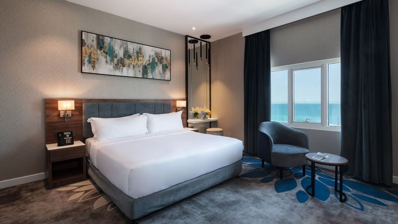 Bed with nightstand and seating in Executive Room Sea View at Warwick Hotels & Resorts