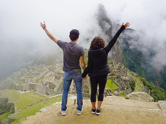 pareja tomada de las manos desde la cima de la montaña cerca de Sumaq Hotel