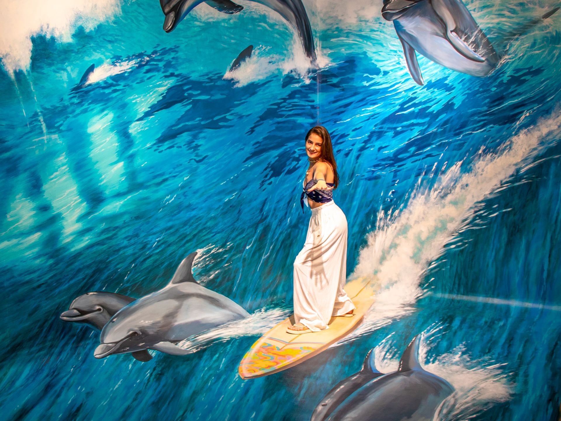 Lady posing by a dolphins wall art at Casa Dona Susana
