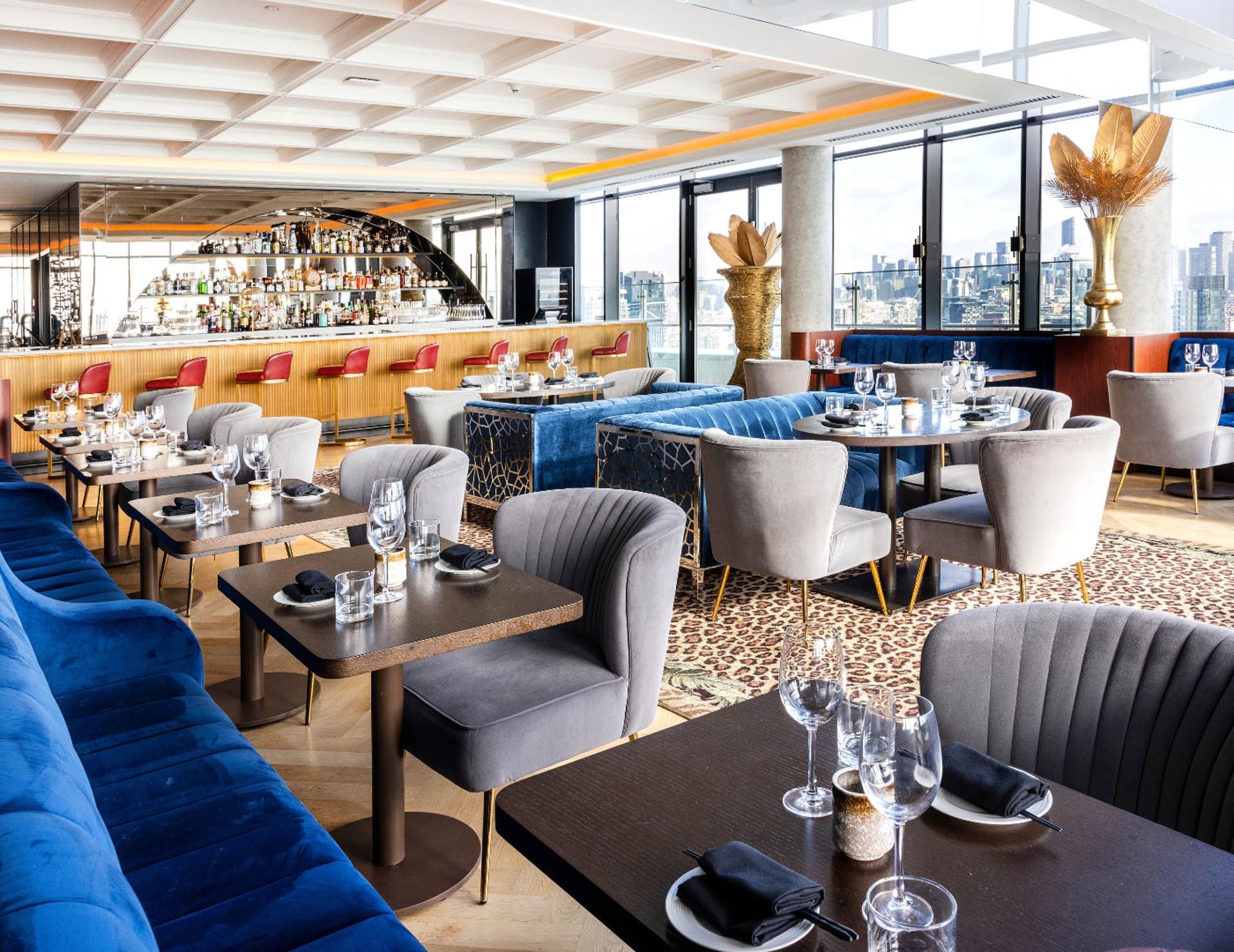 Sièges rembourrés, tables dressées et vue sur la ville à Valérie, l'un des meilleurs restaurants près de l'hôtel X Toronto