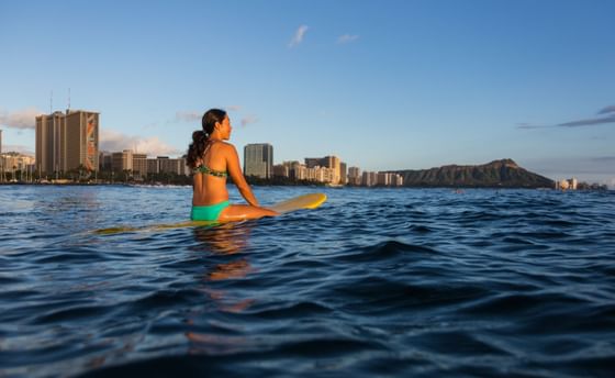 Woman enjoying the waves on a surfboard near Stay Hotel Waikiki