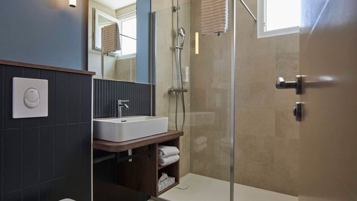 Salle de bain élégante avec douche en verre et lavabo à l'Hôtel La Marébaudière.