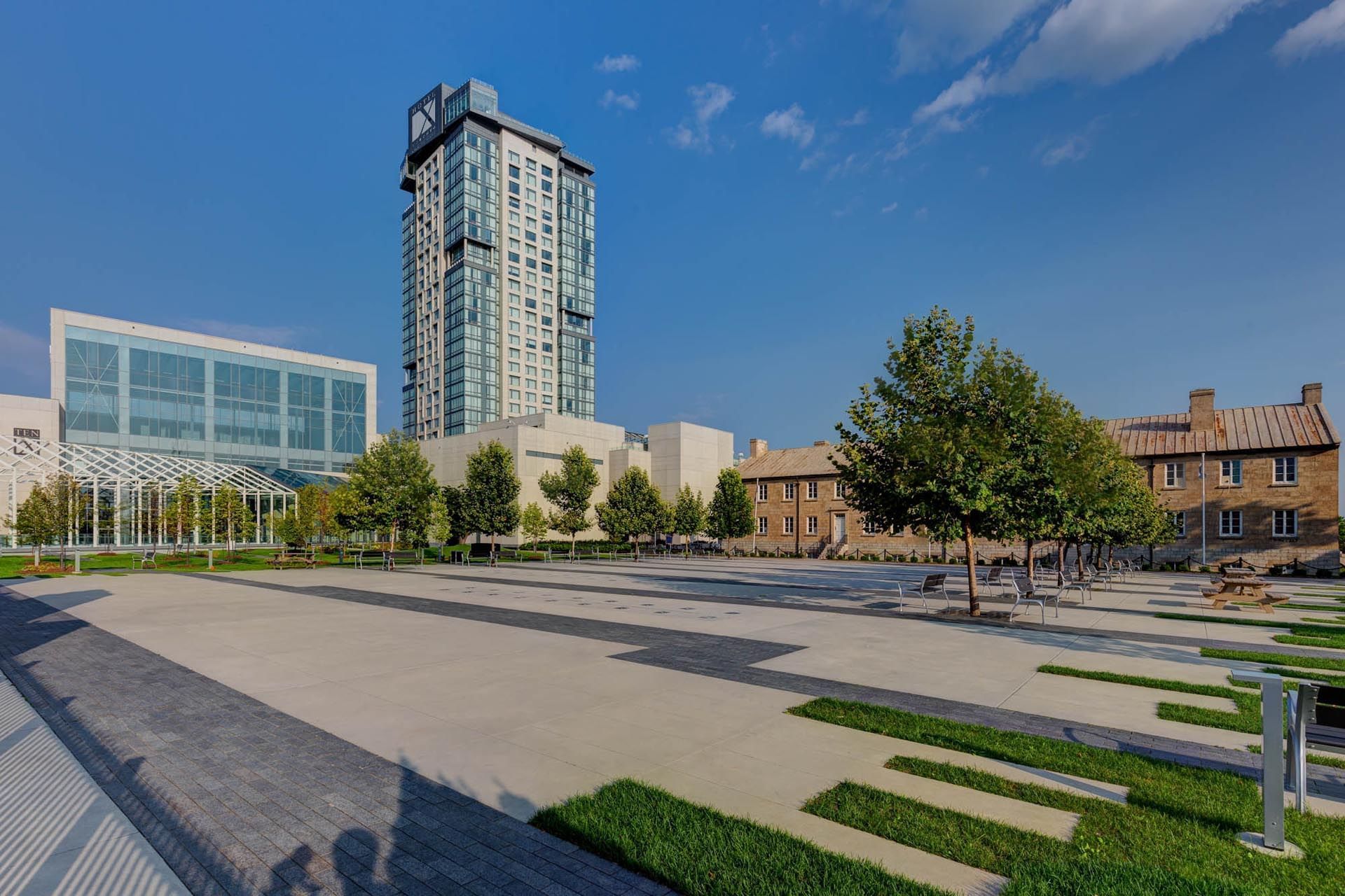 Hotel X Toronto next to Stanley Barracks with trees and a clear blue sky 