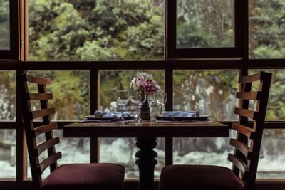 dining table with place settings and two chairs