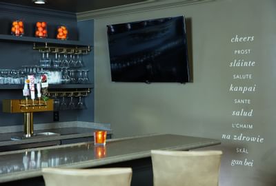Bar counter & a TV with glasses at Ethan Allen Hotel