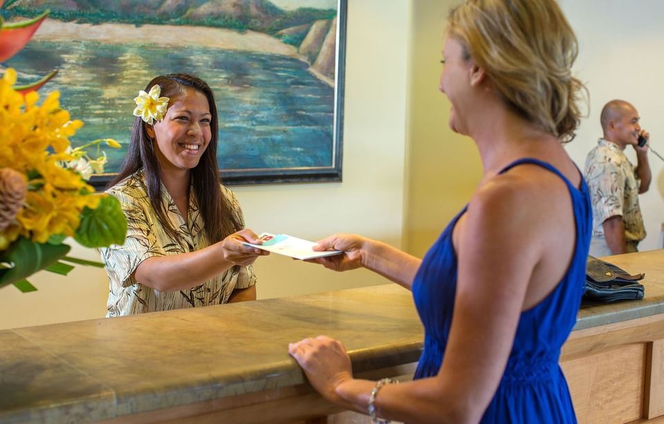 Receptionist & guest greeting with smiles at Maui Coast Hotel