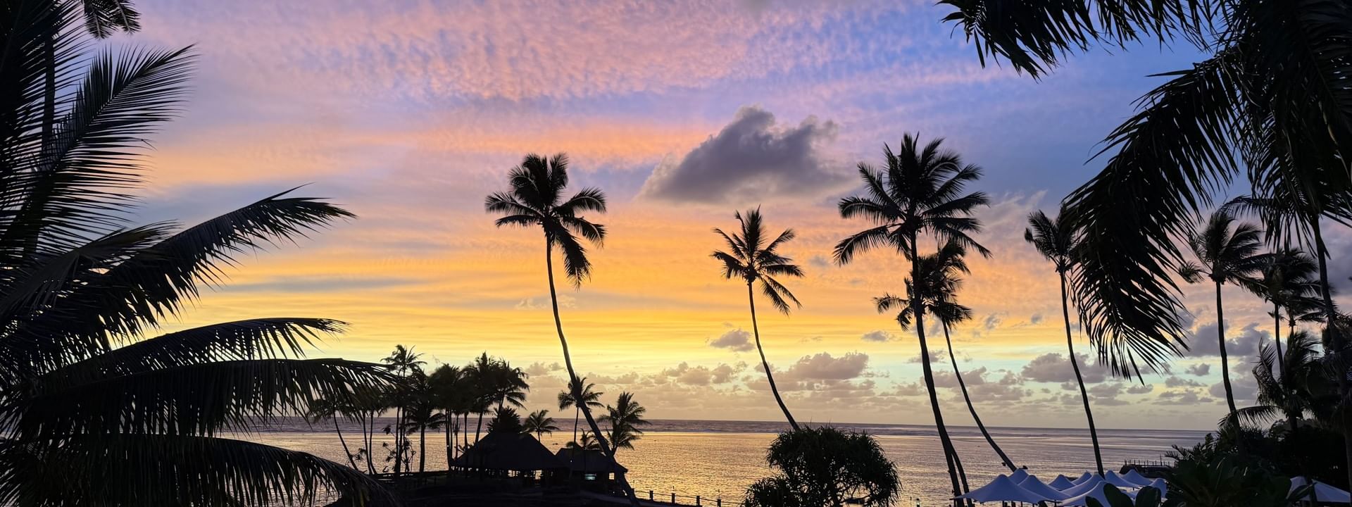 Sunset view over ocean and beach with palm trees at Warwick Fiji Resort and Spa in Korolevu
