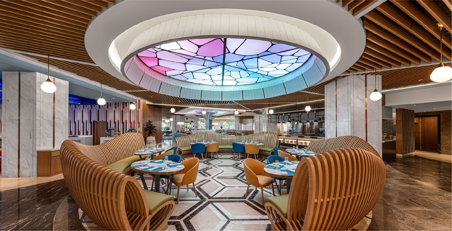 Vibrant hotel restaurant with colorful skylight and unique curved seating at Sunway Resort