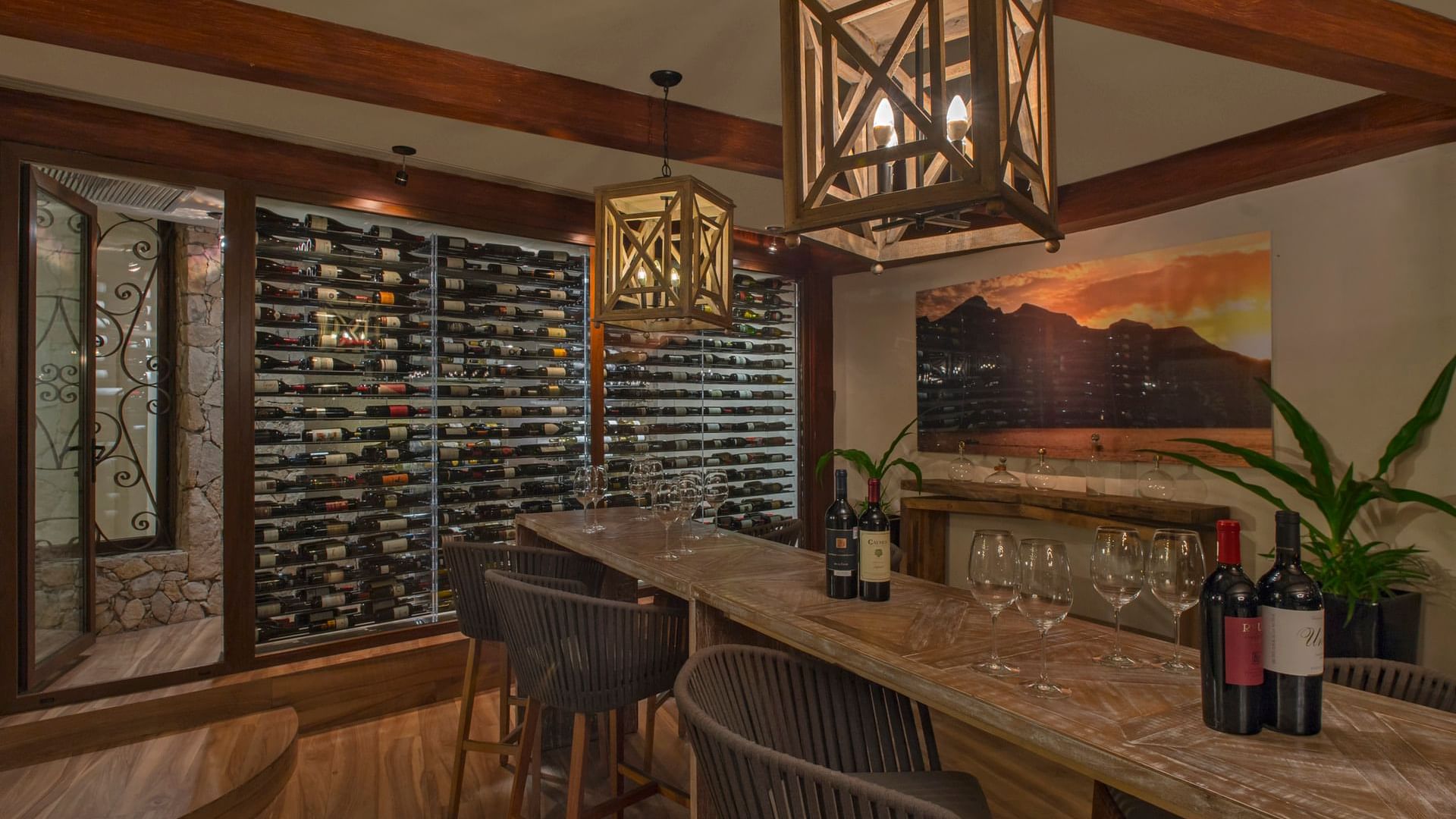 Bodega De Cortez con bar, lámparas rústicas y una pared de botellas de vino en Hacienda del Mar Los Cabos