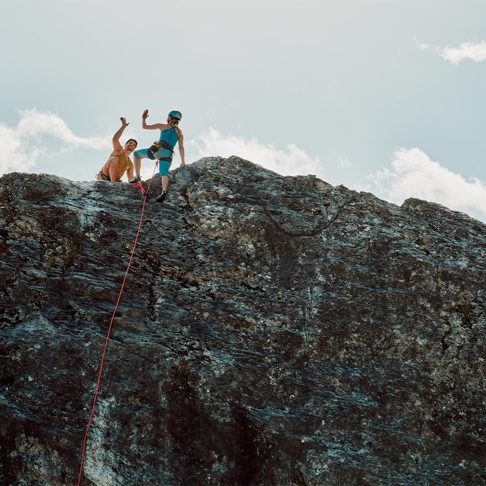 Kletterer am Klettersteig Latschau mit Seilen gesichert, gegen Himmel und Wolken.