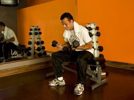 A man doing exercise in fitness center at Porta Hotel Antigua