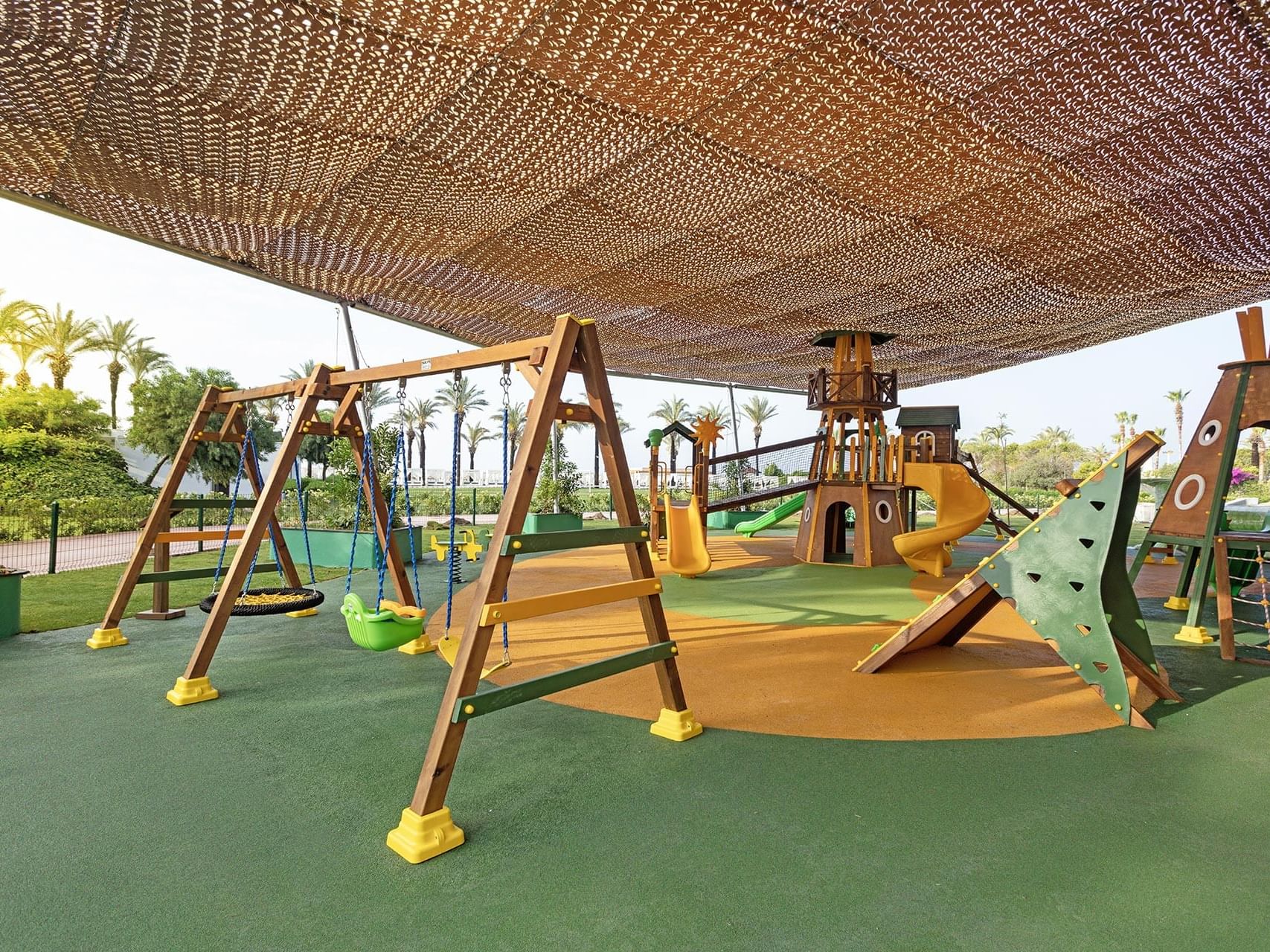 Play area arranged with swings and slides in Kikoa Kids Club at Titanic Deluxe Lara