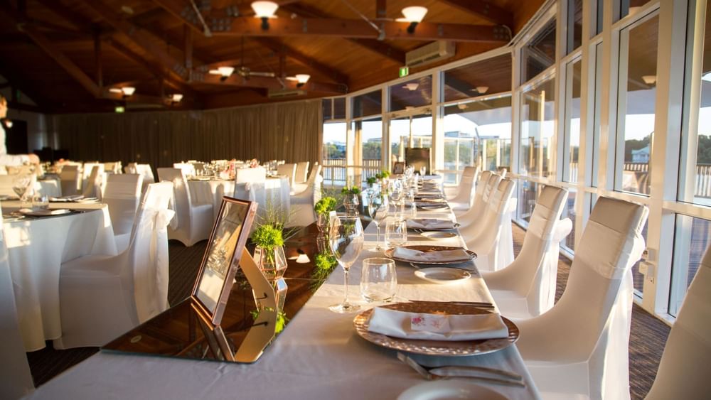 Dining setup by large windows with natural light streaming in Lily’s on the Lagoon at Novotel Sunshine Coast Resort