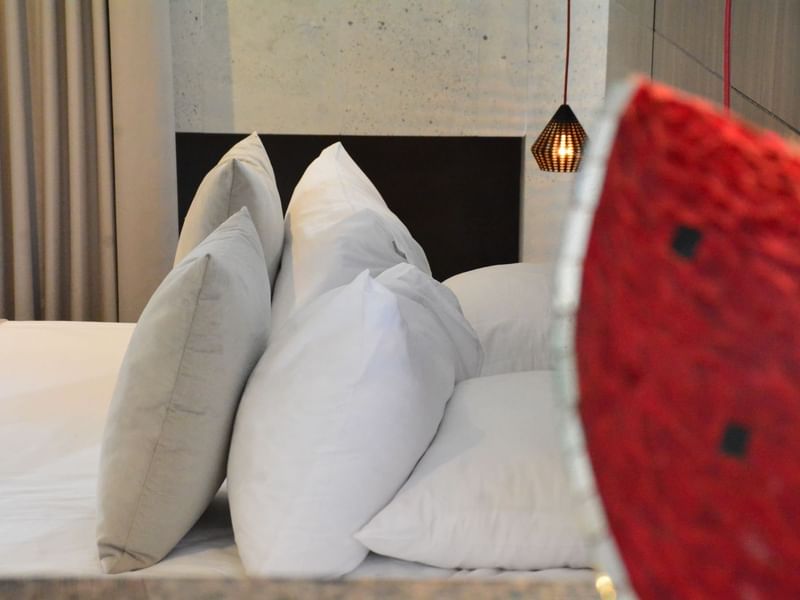 Pillow arrangement on a bed at Ilo Rojo Curamoria Collection