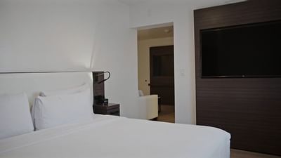 Large bed & wall-mounted TV in a room at The Nest Palo Alto