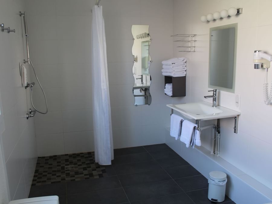 Bathroom shower & vanity area in a room at hotel la terrasse