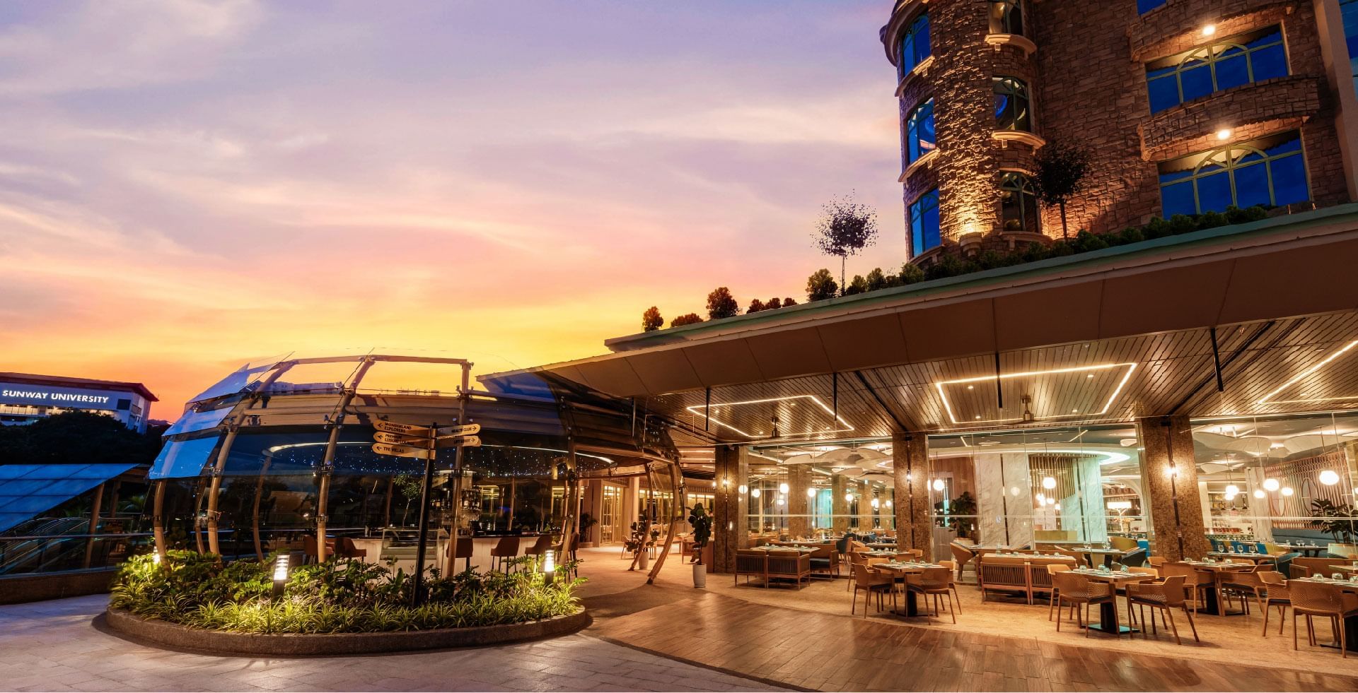 Outdoor restaurant seating at Sunway Lagoon Hotel with a sunset sky
