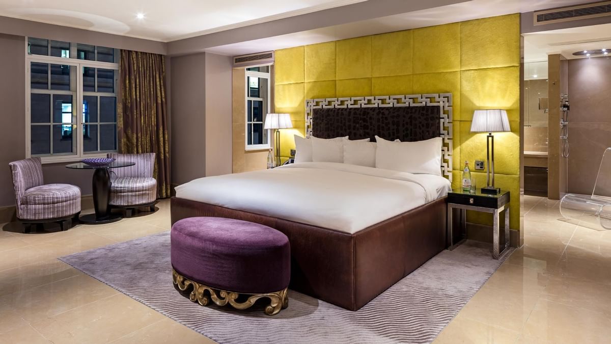 The Amarillo Suite at The May Fair Hotel, London, featuring a large bed with striped chairs and soft lighting