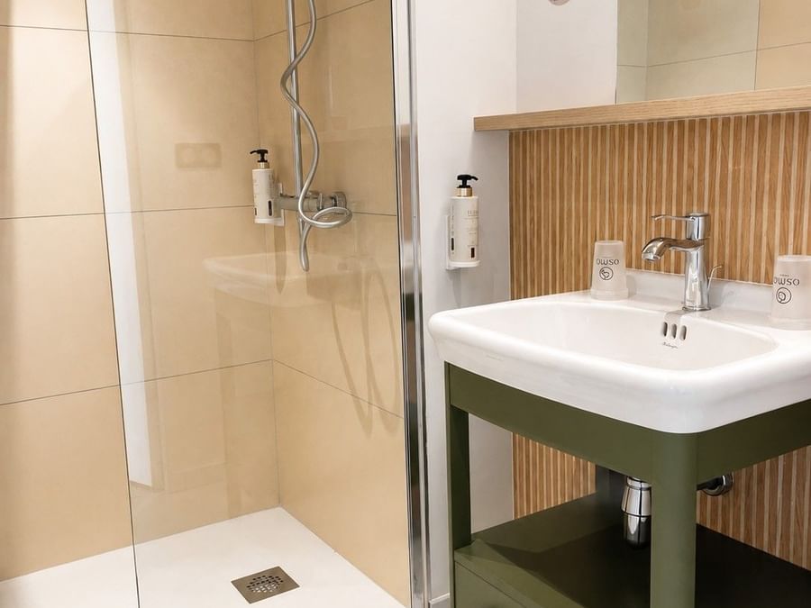 Salle de bain moderne avec douche et lavabo à Osmo Hôtel à Chantepie.