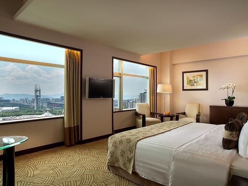 King-size bed with a TV in Executive Suite at Celebrity International Grand Hotel