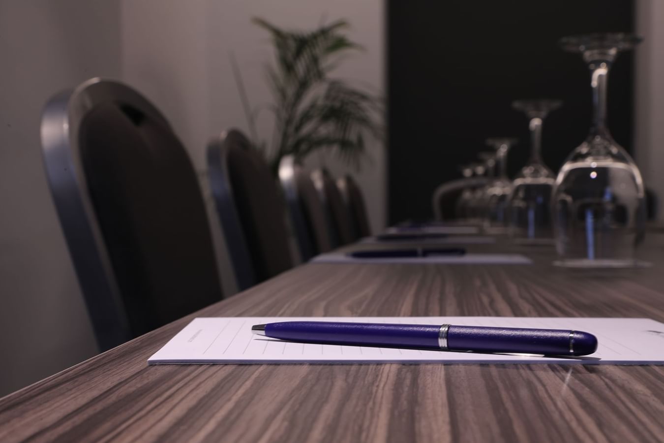 Conference room with a table set up for a meeting with wine glasses and chairs at Warwick Corporate