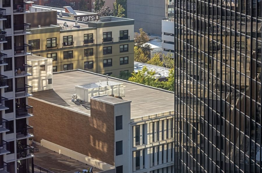 Aerial view of city buildings and a glass skyscraper under soft sunlight near Warwick Seattle