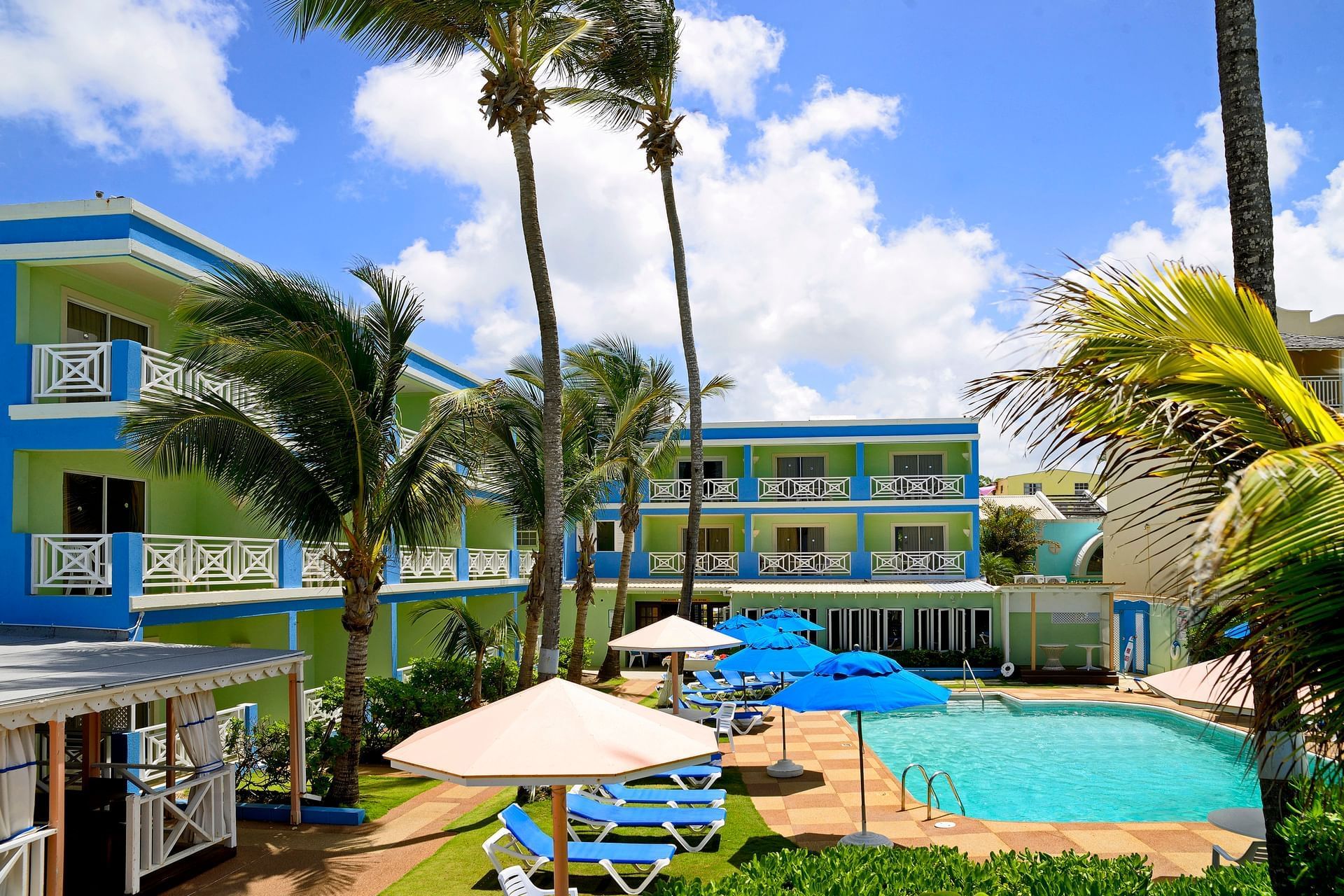 Hotel exterior with Pool and Sundeck surrounded by palm trees at Dover Beach Hotel