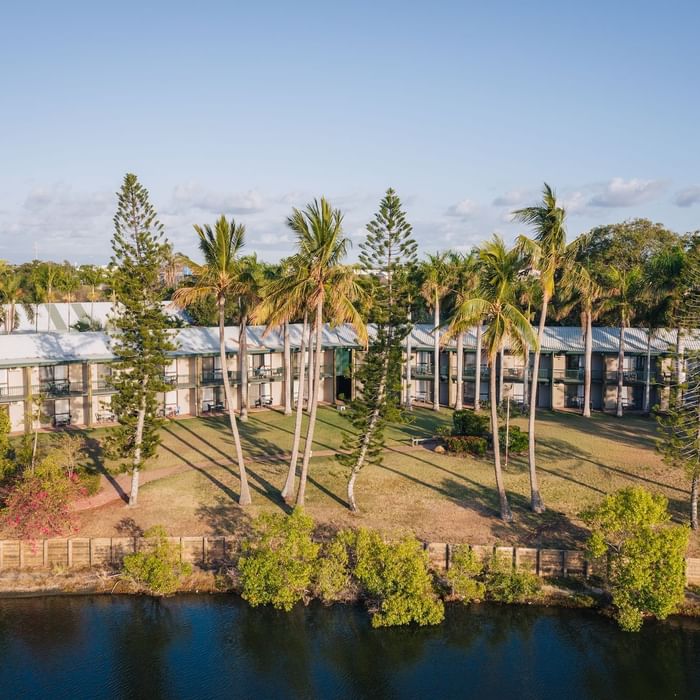 Aerial view of Mercure Hotel Townsville surrounded by palm trees, lush greenery