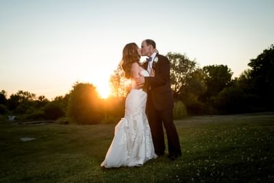 Wedding couple kissing with sunset at La Tourelle Hotel and Spa