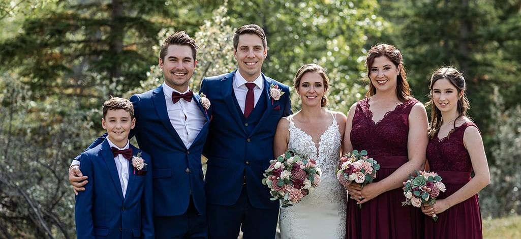 Wedding couple posing with family and bridal party in Canmore.