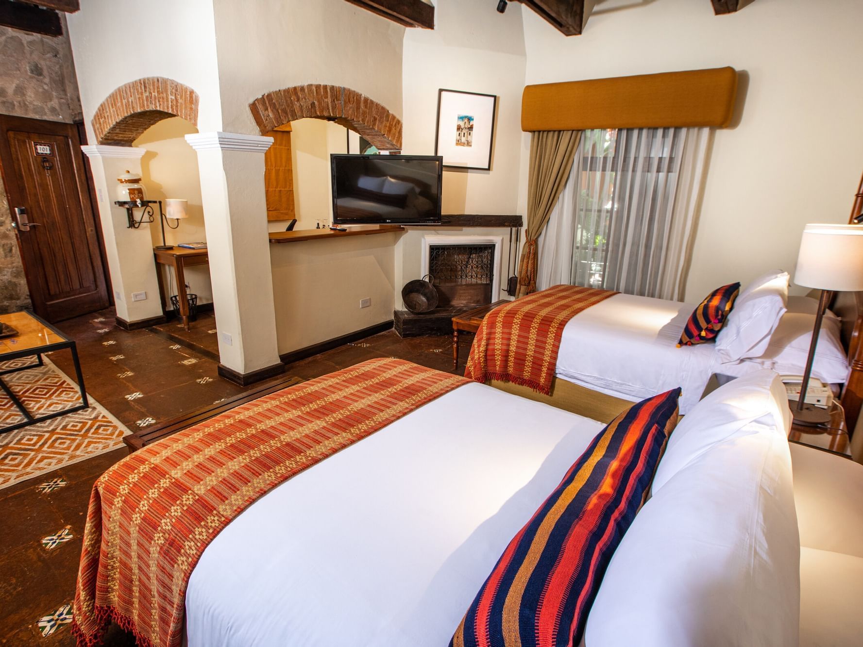 TV & workspace by the bed in Junior Suite Garden at Porta Hotel Antigua