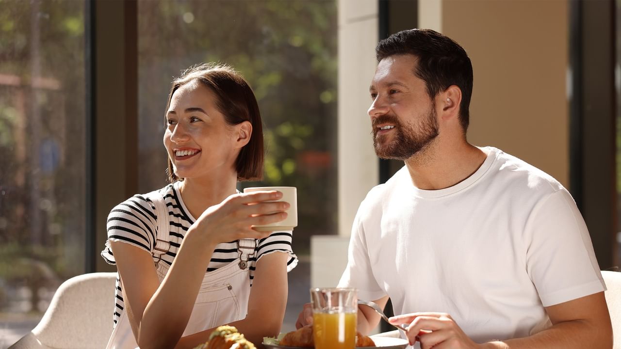 Smiling couple enjoying coffee and breakfast together 