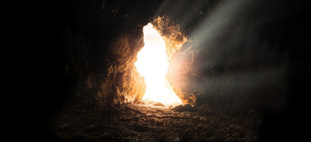 Light shines through a cave exit on a Canmore cave tour.