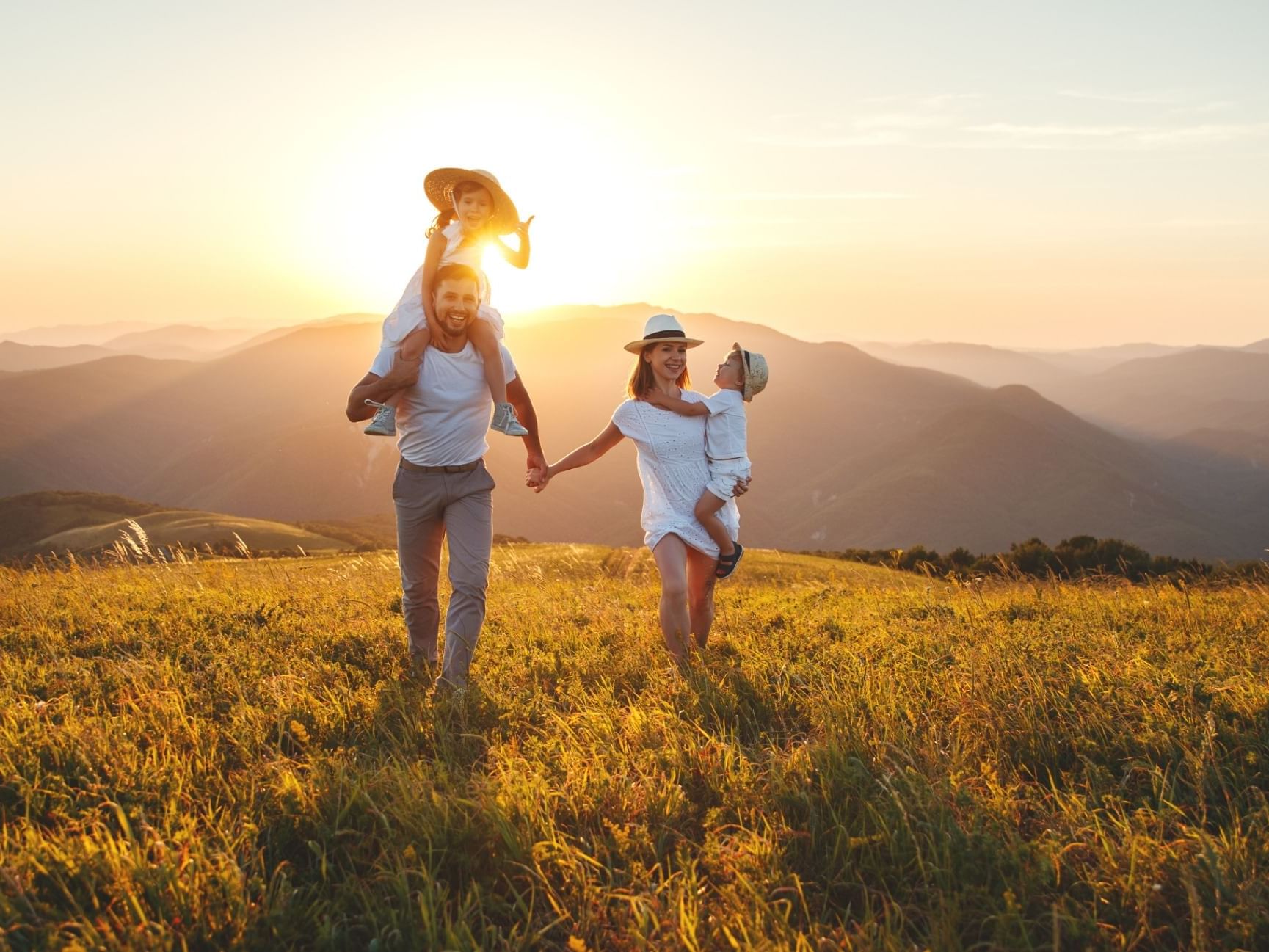 A happy family walking in grassland near Originals Hotels