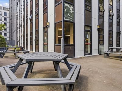 Picnic tables outside a modern building at UniLodge Stafford House.