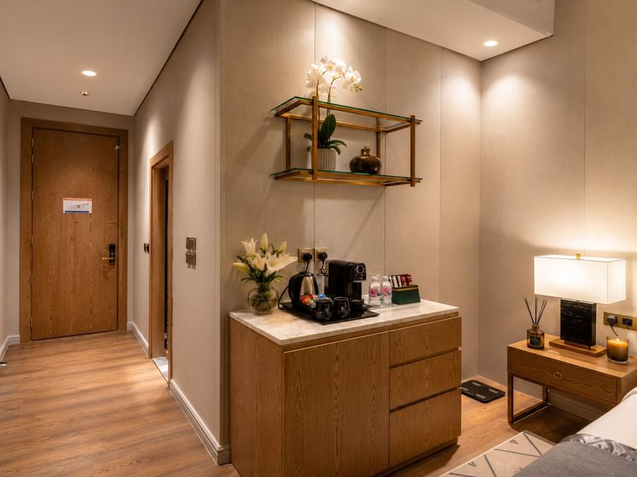 Coffee station cabinet with kettle and cups near hotel doorway in Accessible room at Naviti by Warwick Jeddah 